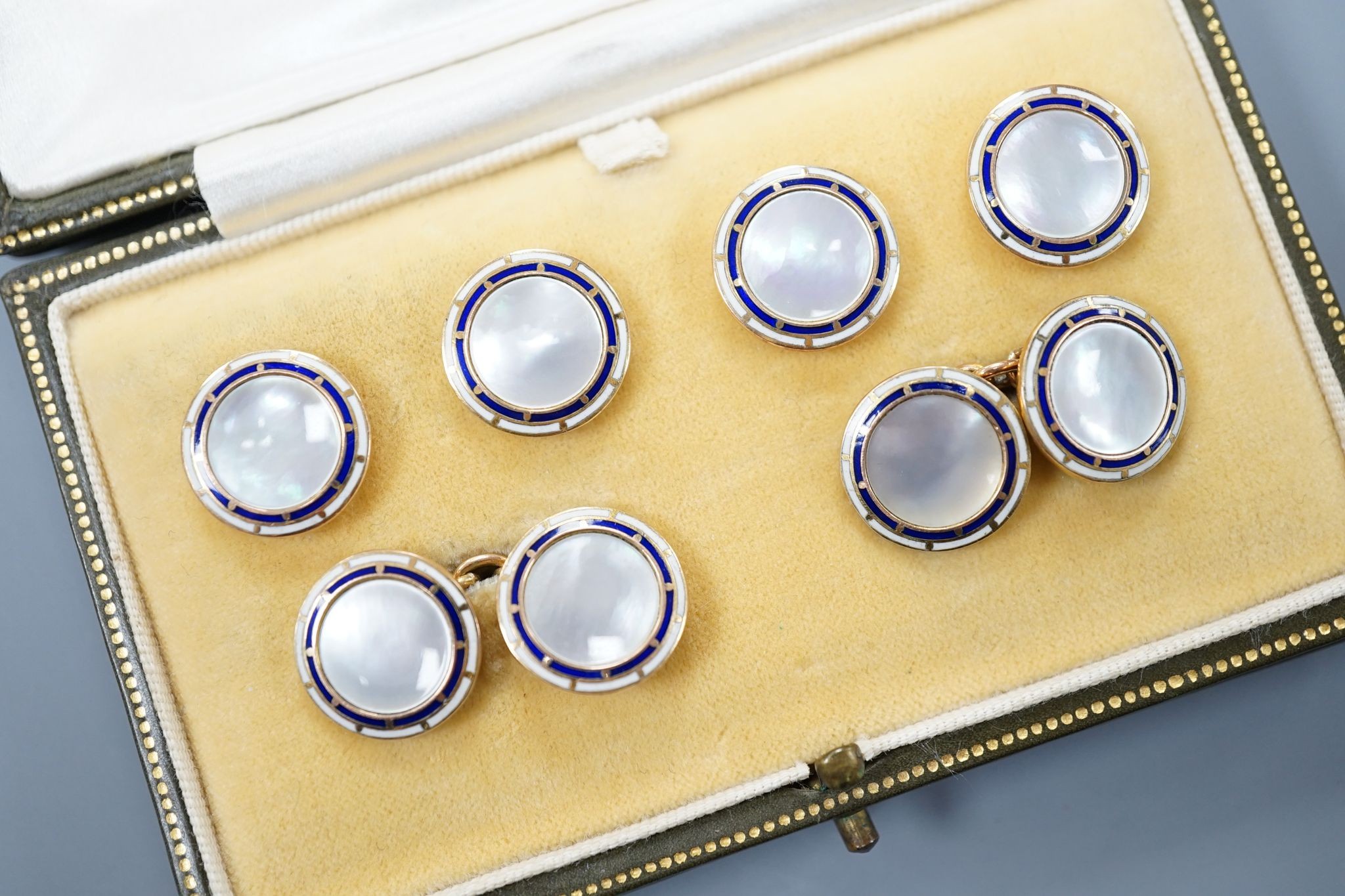 A cased 9ct, mother of pearl and enamel set six piece dress stud set, gross set 10.3 grams